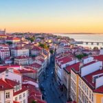 Scenic Lisbon view with historic buildings and river.